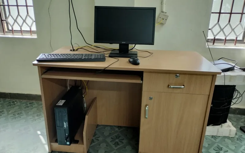Escritorio de madera con monitor, teclado y cajón abierto